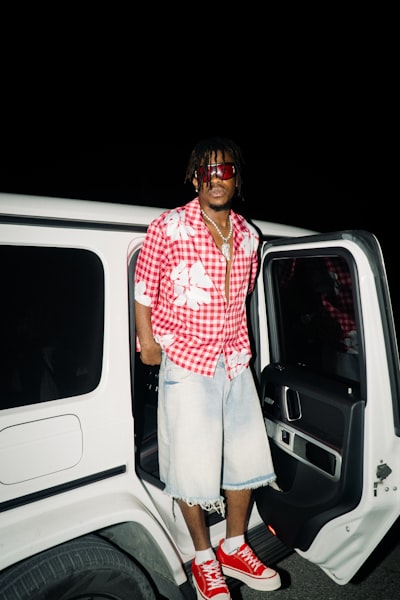 Man In Red Checkered Shirt Stands By White Suv. wallpaper preview