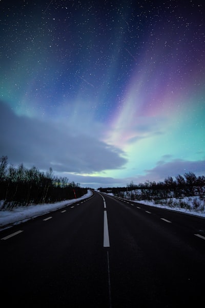 Aurora Borealis Over A Snowy Road And Starry Night. wallpaper preview
