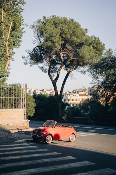 Vintage Red Convertible Car Parked On A Sunny City Street.