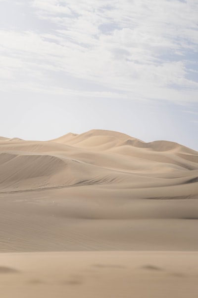 Rolling Sand Dunes Under A Cloudy Sky