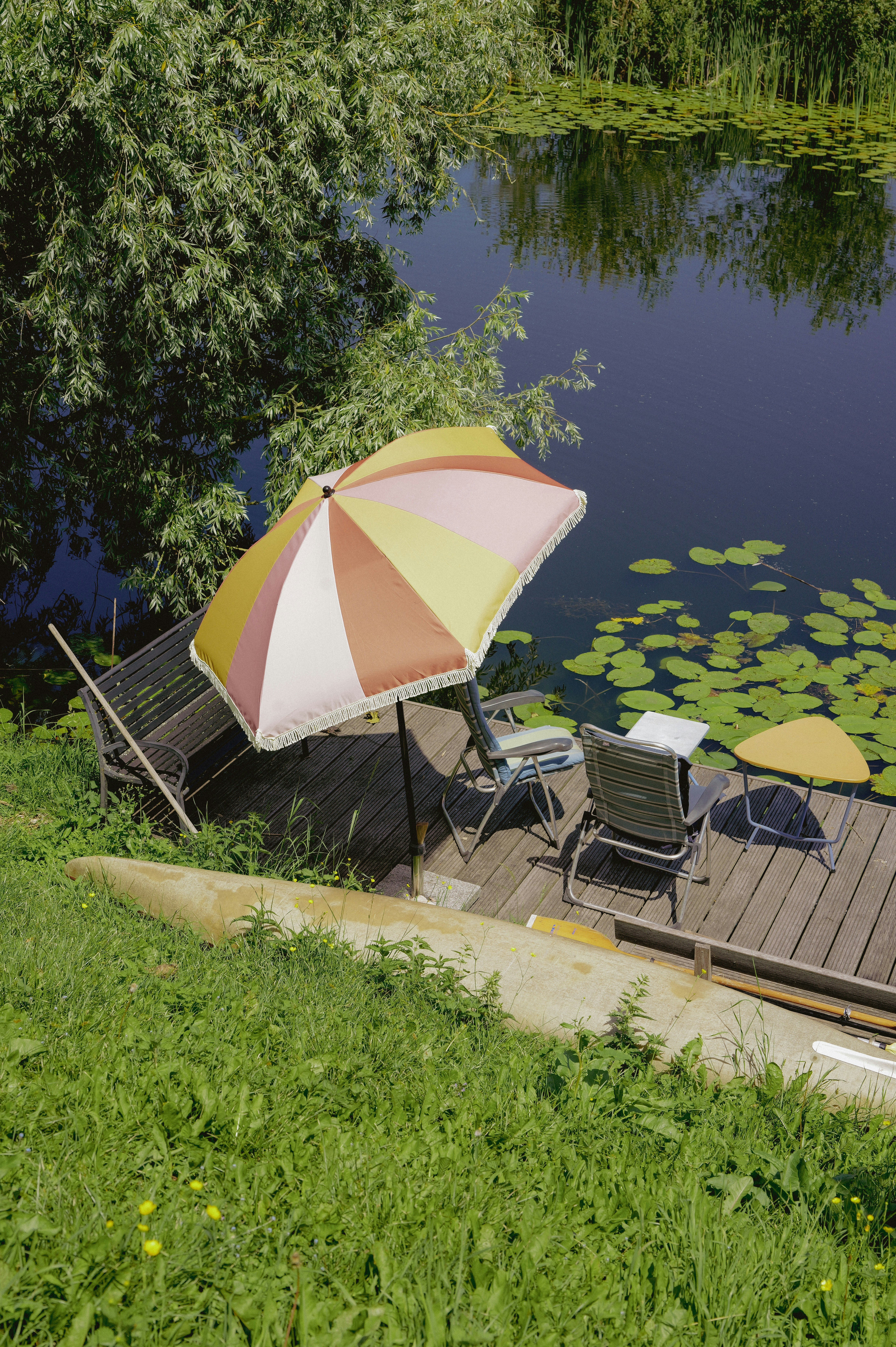 Relaxing Dock With Umbrella, Chairs, And Lily Pads On Water. HD mobile wallpaper