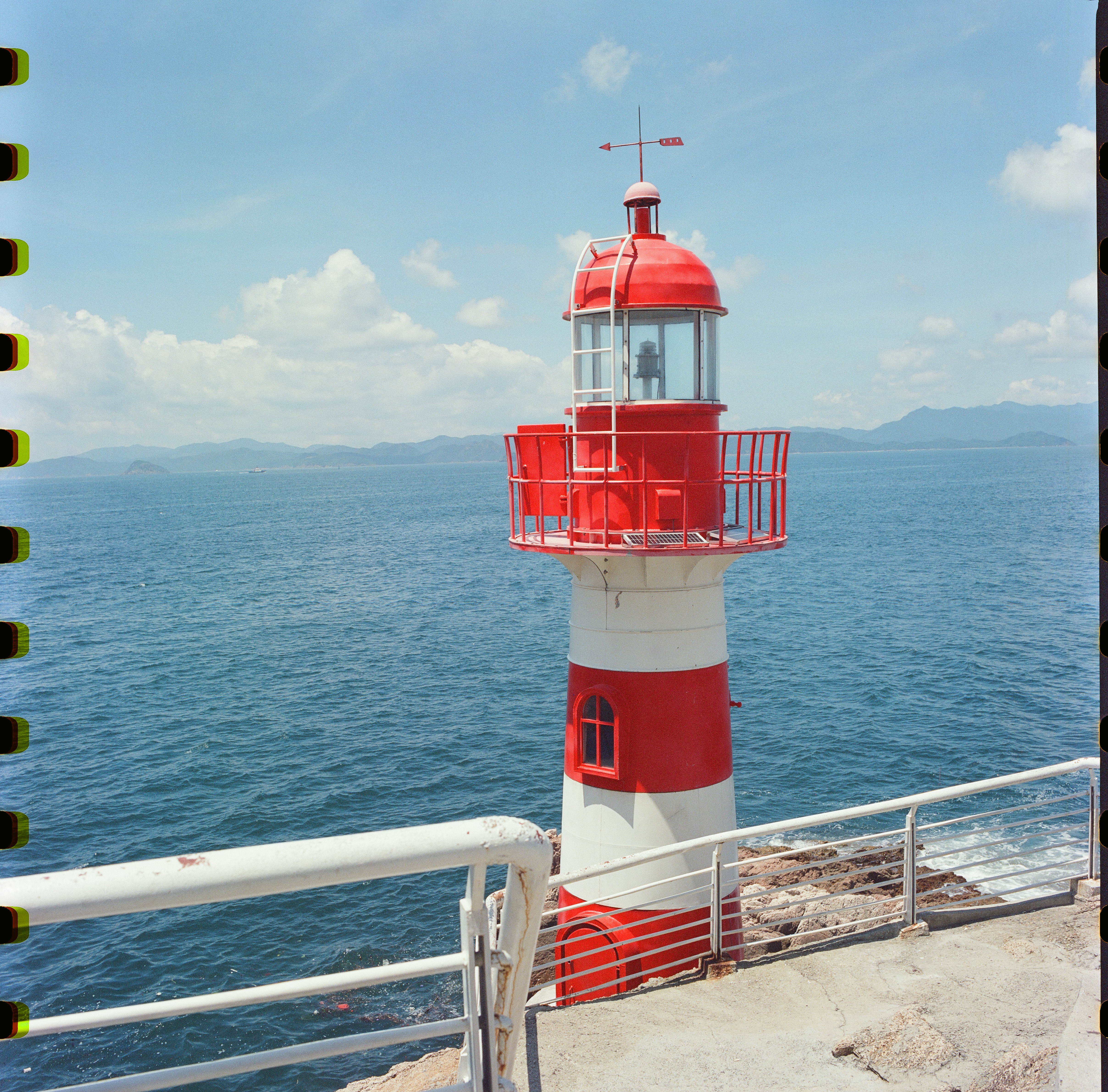 A Red And White Lighthouse Stands By The Blue Ocean. HD mobile wallpaper
