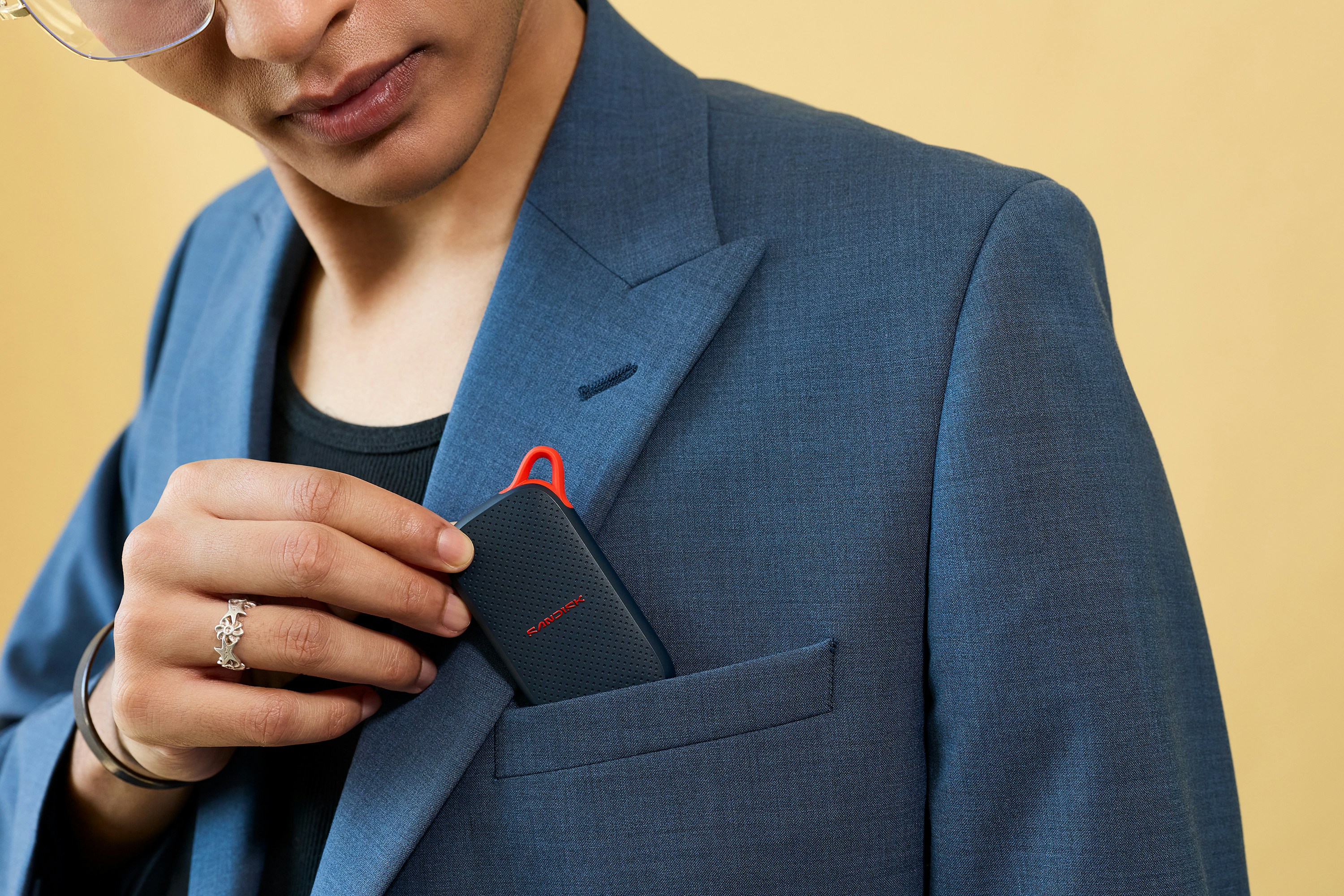 Hand Inserting A Black Electronic Device Into A Blazer Pocket. HD mobile wallpaper