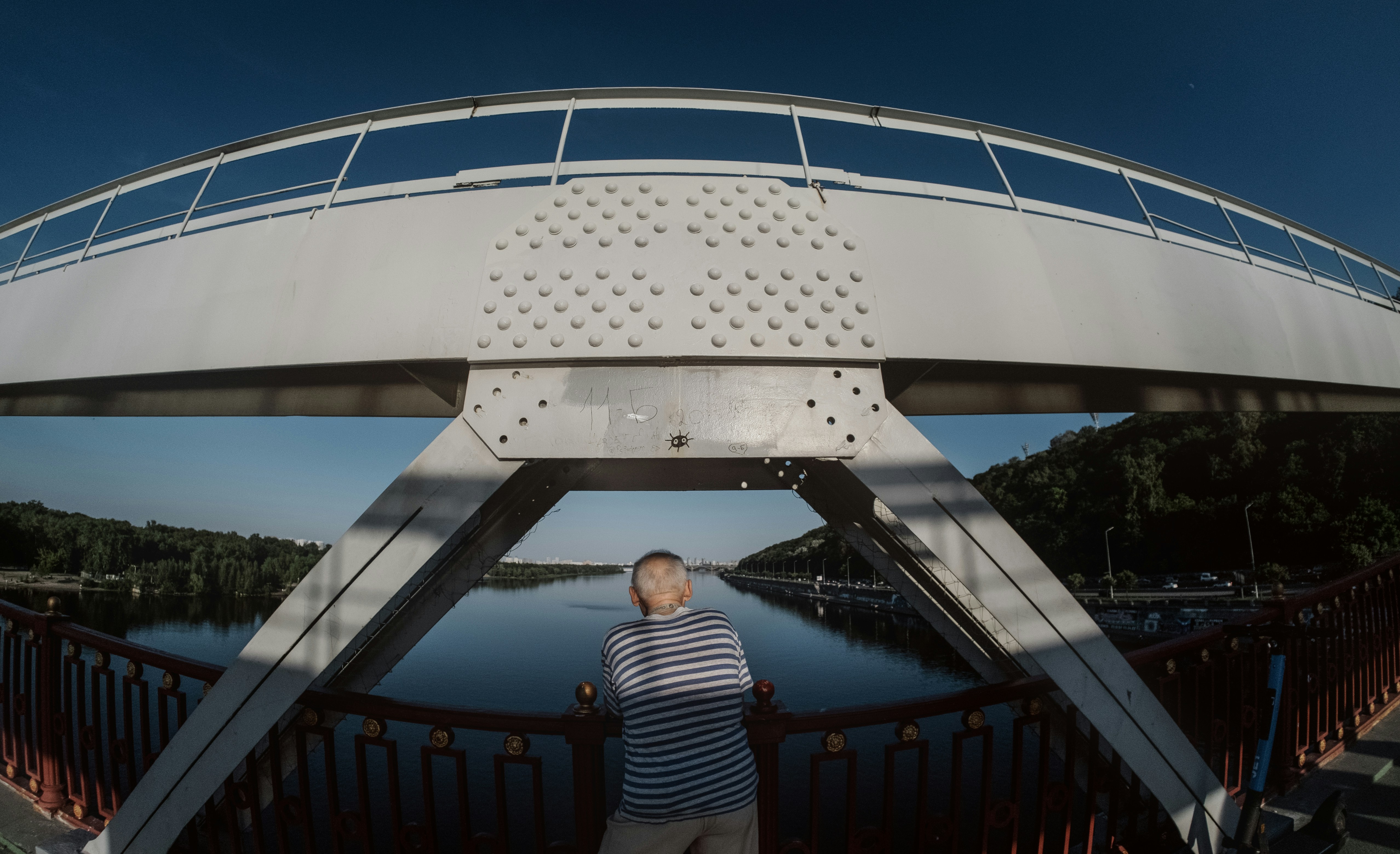 Man In Striped Shirt Stands On Bridge Overlooking River. HD mobile wallpaper