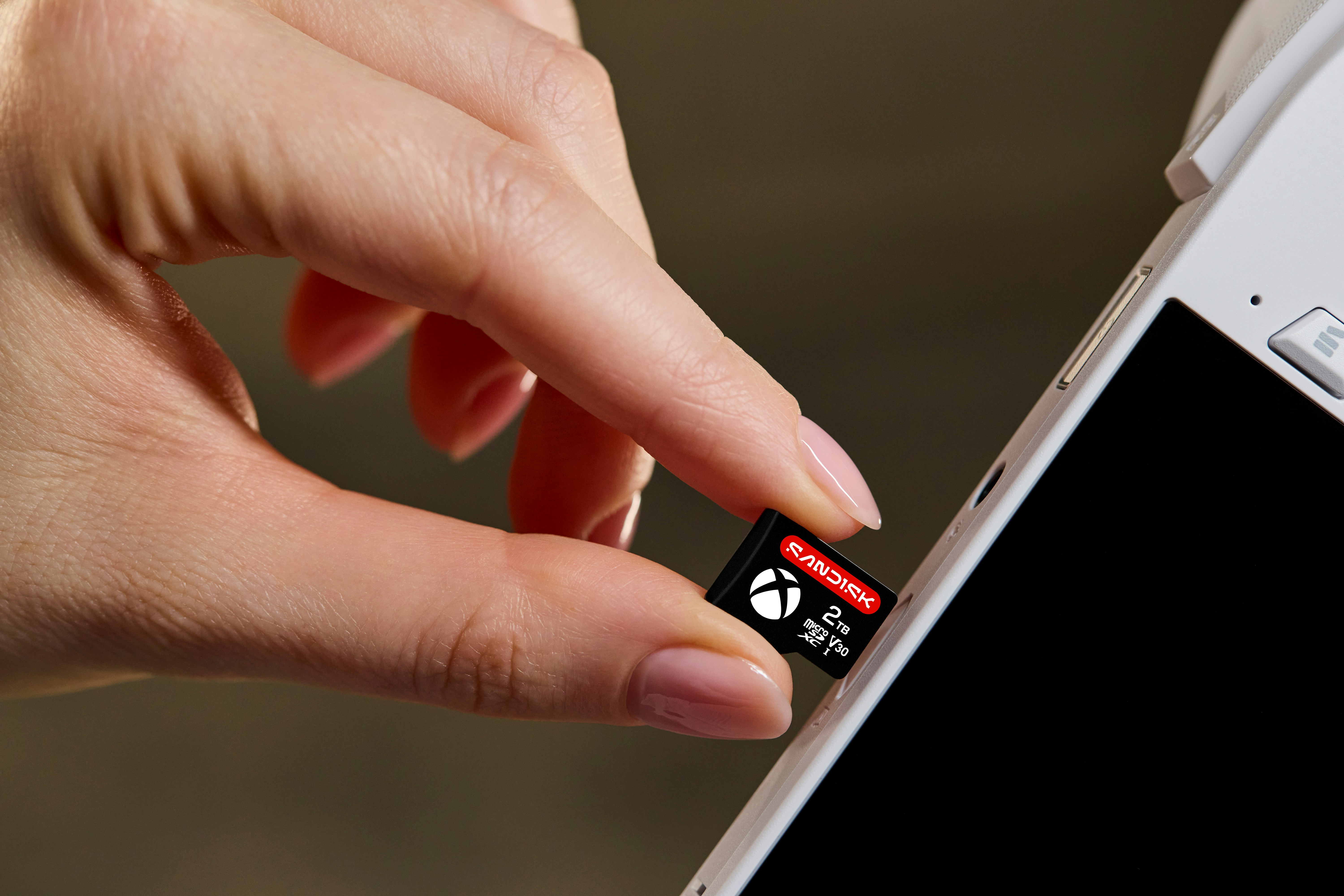 Hand Inserting A Memory Card Into A White Electronic Device. HD mobile wallpaper