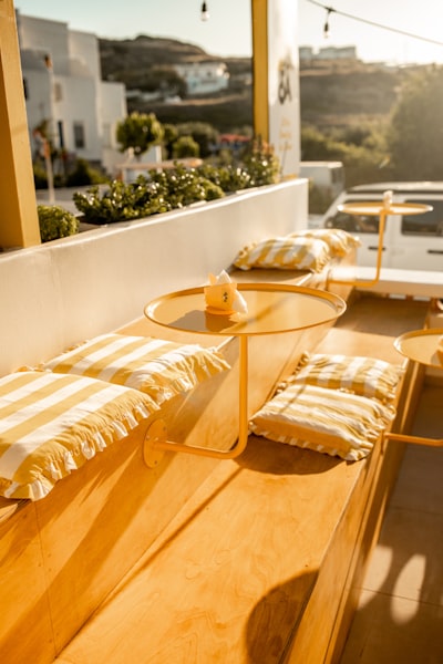 Sunny Outdoor Cafe With Yellow Furniture In Milos wallpaper preview