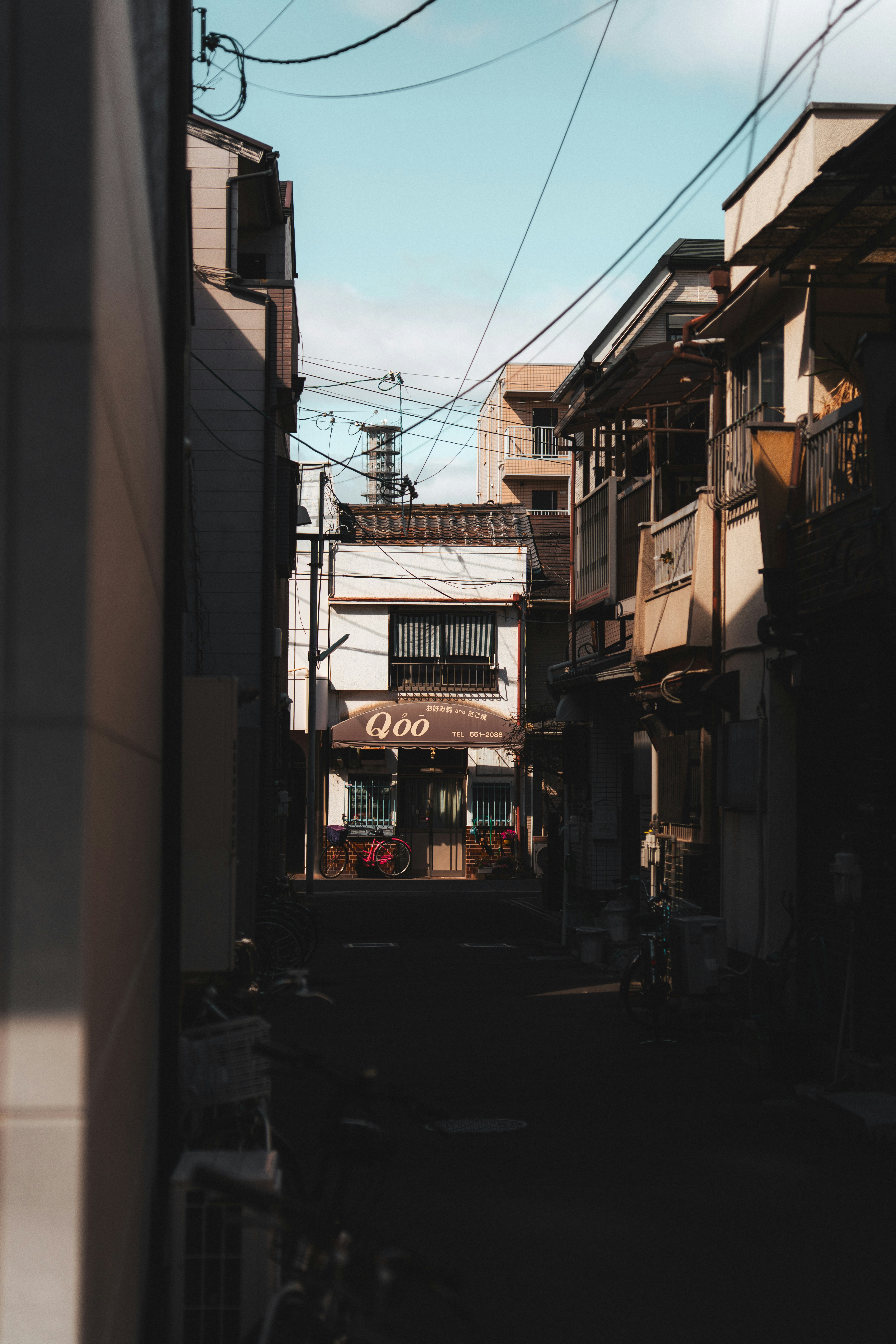 Narrow Urban Alleyway With Buildings And Overhead Power Lines. HD mobile wallpaper
