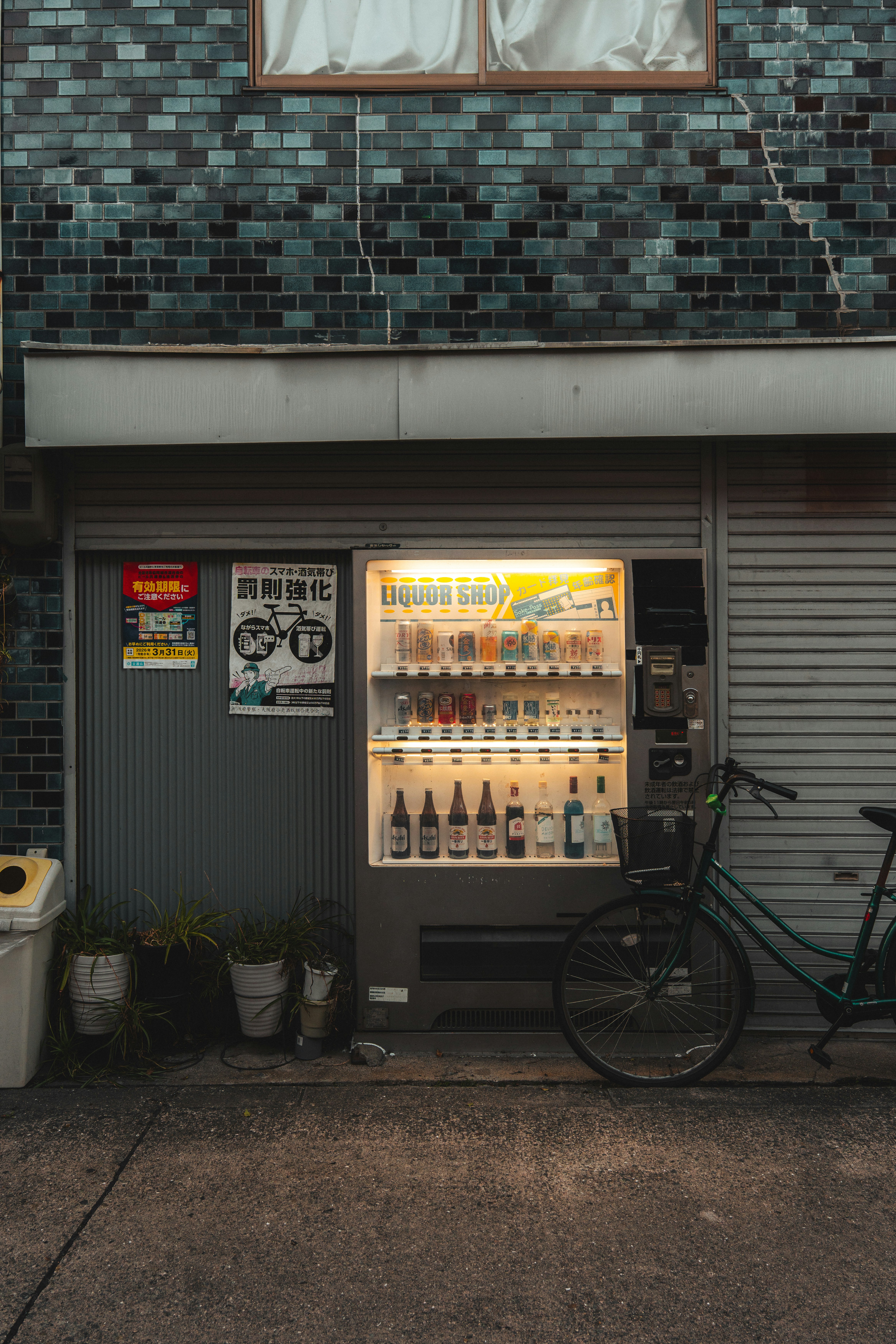 Illuminated Liquor Vending Machine With A Bicycle Parked Outside. HD mobile wallpaper