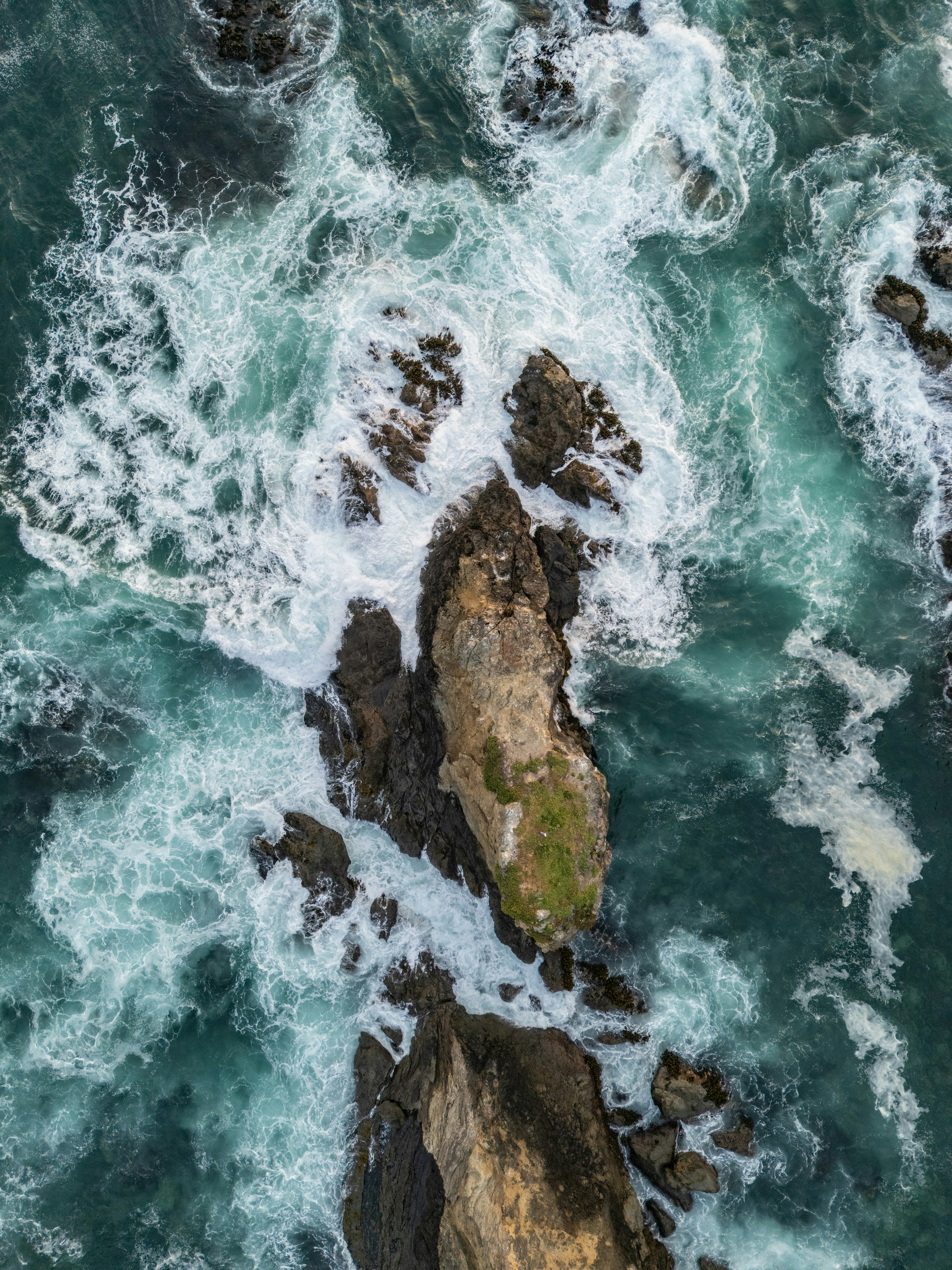 Rugged Rocks Surrounded By Foamy Turquoise Ocean Waves. HD mobile wallpaper