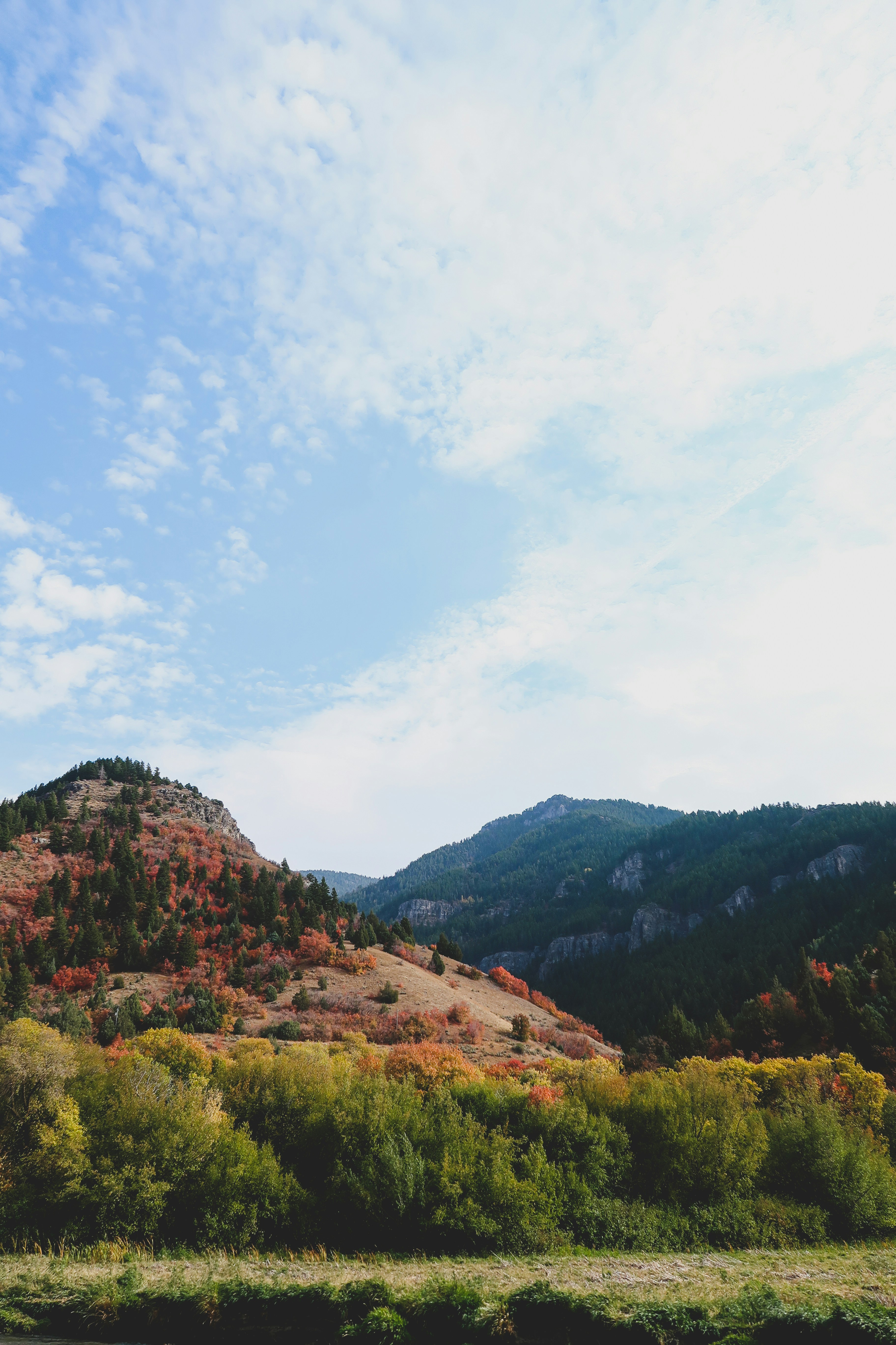 Green And Brown Mountains Under White Clouds And Blue Sky During Daytime
