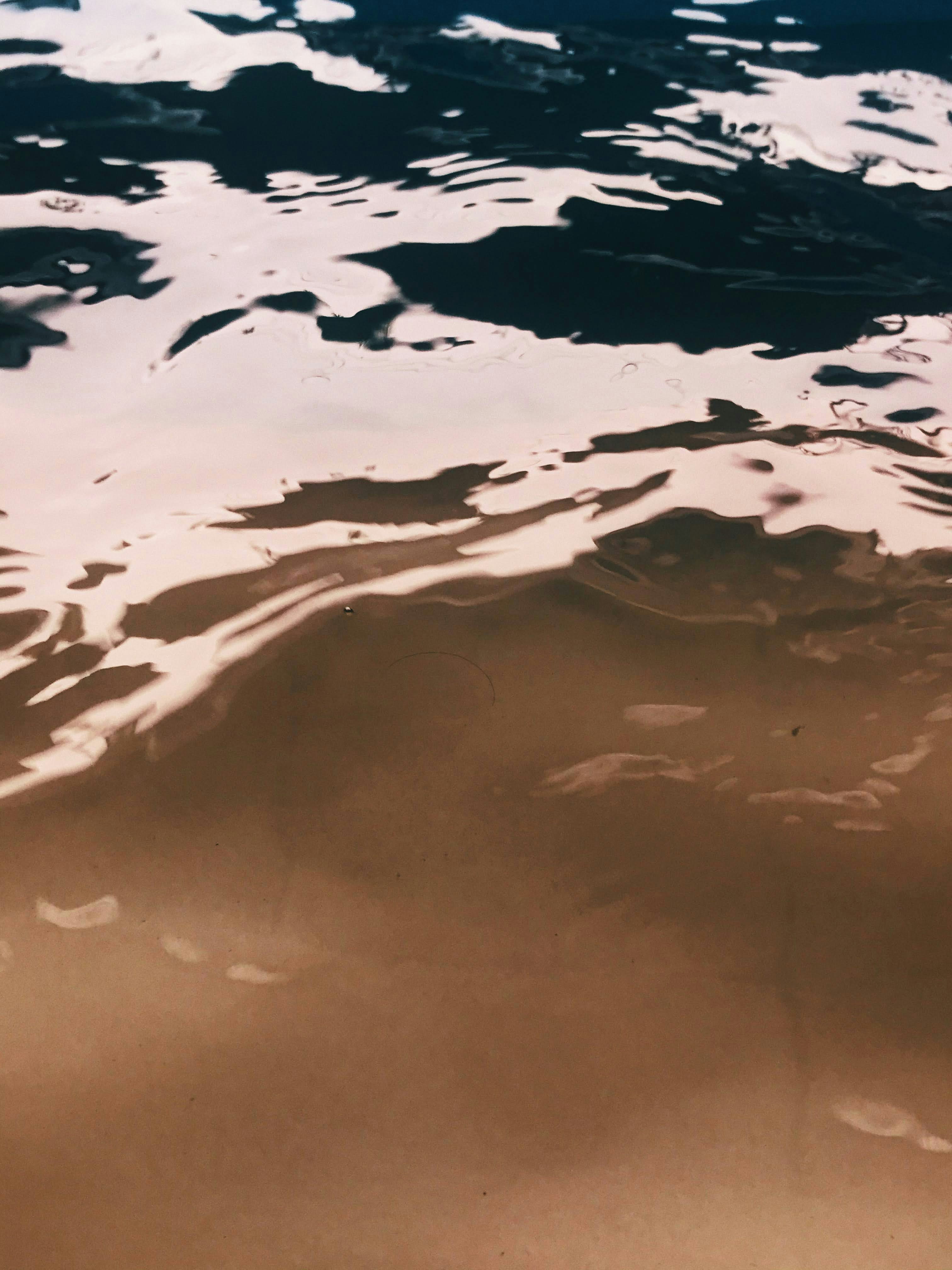A Person Riding A Surfboard On Top Of A Body Of Water
