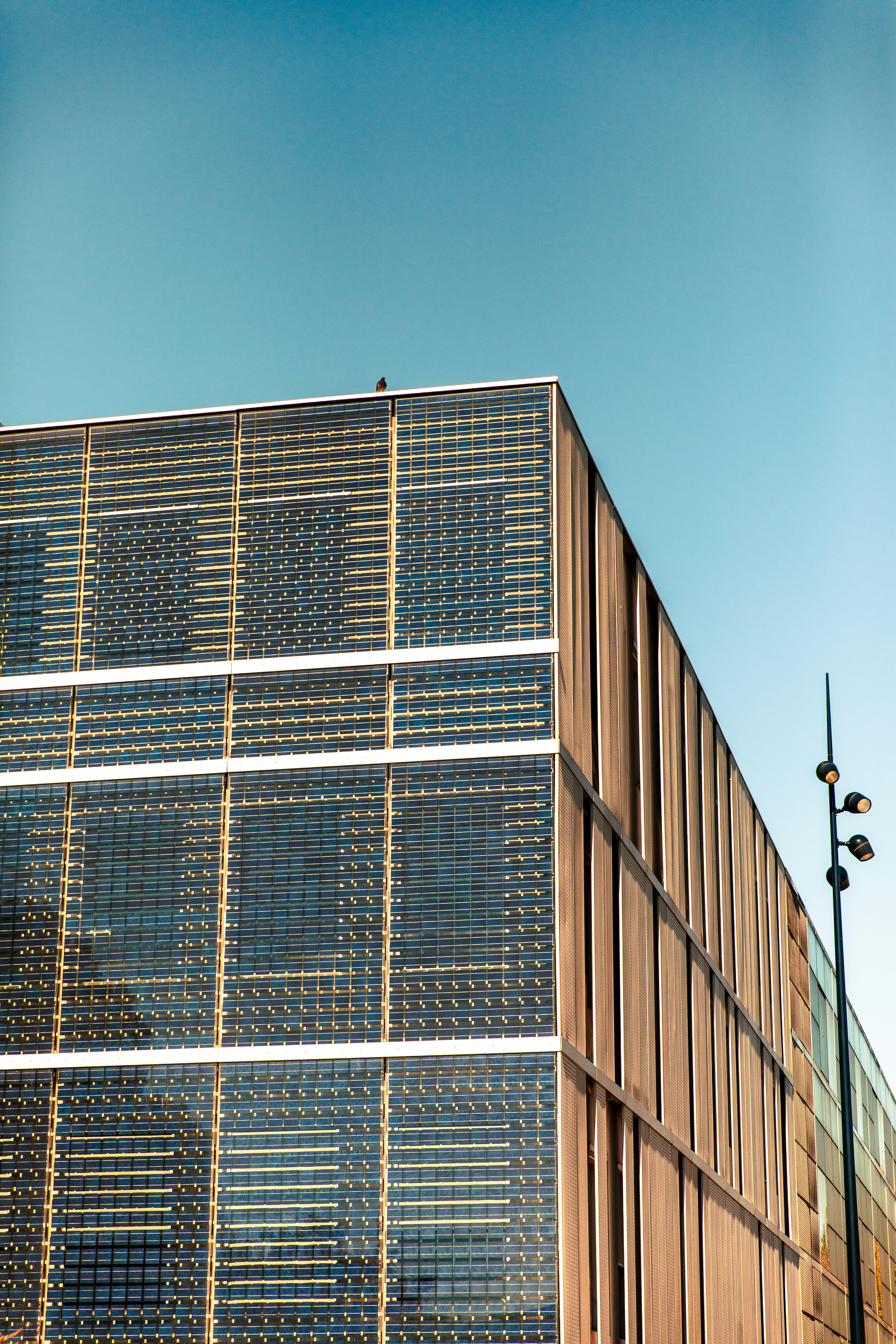 A Tall Building With Lots Of Windows Next To A Street Light